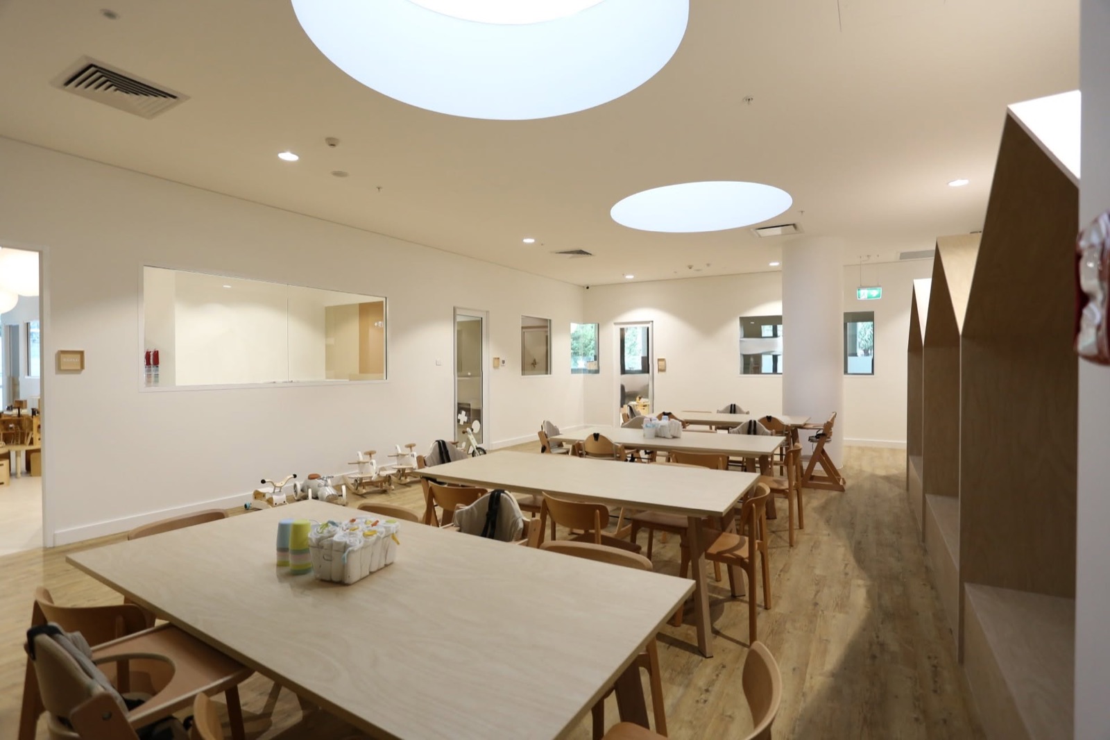 Our dining room with long wooden tables under round skylights